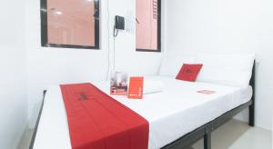 um quarto com uma cama com uma caixa vermelha em RedDoorz @ El Grande Inn Santa Cruz Manila em Manila