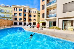 a person swimming in a swimming pool in a building at Silver - Apartment for 4 guests 150m from beach in São Martinho do Porto