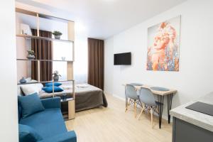 a living room with a bed and a dining room at MYFREEDOM Апартаменти метро Почайна in Kyiv