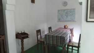 a dining room with a table and chairs and a clock at House Colonial in Talalla South