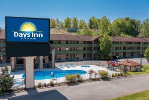 un panneau devant un hôtel avec piscine dans l'établissement Days Inn By Wyndham Pigeon Forge South, à Pigeon Forge