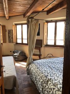 Un dormitorio con una cama en una habitación con ventanas. en La Marzagrappola, en Moggiona