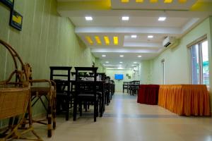 a dining room with chairs and tables in a room at CLUB 99 SUITES in Kakkanad +3 photos