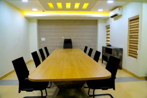 a conference room with a wooden table and chairs at CLUB 99 SUITES in Kakkanad