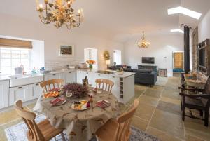 eine Küche und ein Wohnzimmer mit einem Tisch und Stühlen in der Unterkunft Stables Cottage in Perth