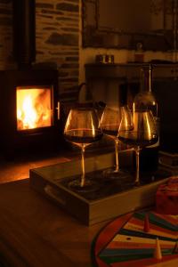 três taças de vinho numa bandeja ao lado de uma lareira em Stables Cottage em Perth