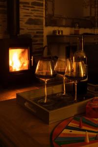 three wine glasses on a tray next to a fireplace at Stables Cottage in Perth