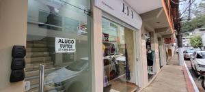 a window of a store with a sign on it at Suite climatizada, ao lado da praca principal in Domingos Martins