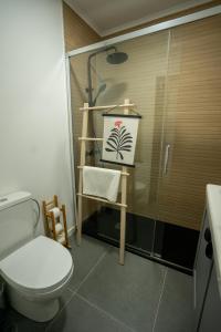 a bathroom with a toilet and a painting of a palm tree at Olivais Apartment River View in Lisbon
