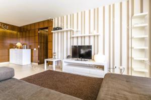 a living room with a tv on a white shelf at Apartamento Chocolate - 300 meters from Salgados beach in Guia
