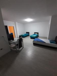 Pokój z 3 łóżkami, stołem i krzesłami w obiekcie Villa Abi Center w mieście Struga