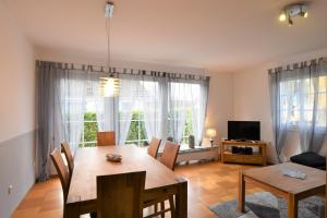 a living room with a dining room table and a television at Haus Lotti - a27182 in Kellenhusen