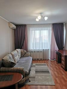 a living room with a couch and a table at 1 комнатная квартира в самом центре с видом на сквер in Kostanay