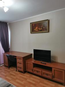 a room with a desk with a television and a desk sidx sidx sidx at 1 комнатная квартира в самом центре с видом на сквер in Kostanay