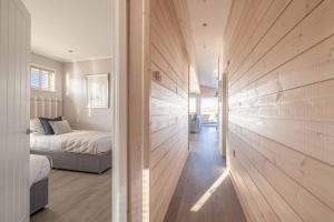 a bedroom with a bed and a wooden wall at Stylish Lodge At Windsor Racecourse Marina in Windsor