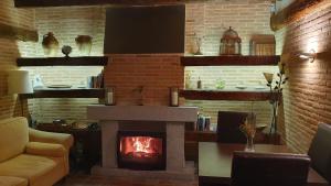 sala de estar con chimenea y sofá en El Rincón de Rascafría en Rascafría