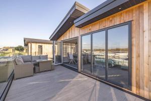 Casa con patio con sofá y mesa en Stylish Lodge At Windsor Racecourse Marina en Windsor