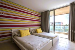 a room with two beds and a striped wall at Apartamento Chocolate - 300 meters from Salgados beach in Guia