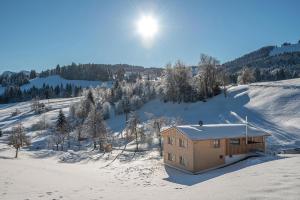 Una casa nella neve su una collina innevata di Lohansler Hütte a Oberstaufen