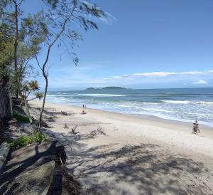 una playa con gente en la arena y el océano en casa da Lú, en Florianópolis