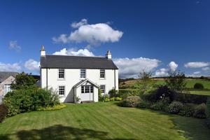 a white house with a large lawn in front of it at Laverockbank Farmhouse in Perth