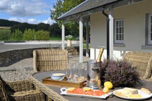 a table with food and a bottle of wine on it at Laverockbank Farmhouse in Perth