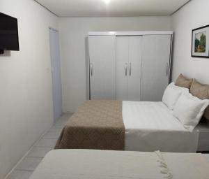 Dormitorio pequeño con cama y armario en casa da Lú, en Florianópolis