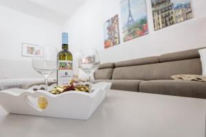 Una botella de vino y dos copas en una mesa en Apartments Pia, en Subotica