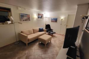 uma sala de estar com um sofá e uma cadeira em Flott leilighet i stille og rolig område, med gratis privat parkering! em Stavanger