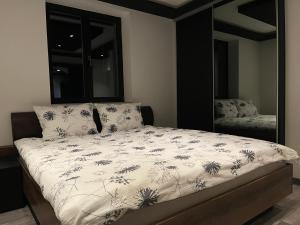 a bedroom with a bed with a black and white comforter at Ranch Falcone in Hrvatska Dubica