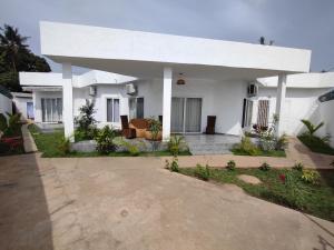 Cette grande maison blanche dispose d'une grande terrasse. dans l'établissement Villa N'KOMI, à Lomé