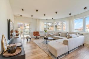 a living room with a couch and a table at Villa Paradis - De ultieme kustvilla met zwembad ! in Koksijde