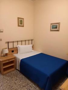 Hotel Don Pedro في بورتوسكوسو: غرفة نوم بسرير ازرق وموقف ليلي