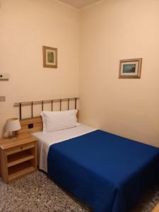 a bedroom with a blue bed and a night stand at Hotel Don Pedro in Portoscuso