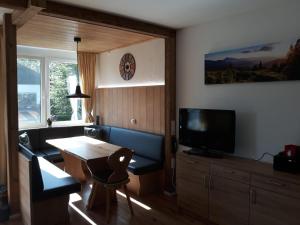 un soggiorno con divano, tavolo e TV di Falkenberg-Wohnung-112 a Oberstdorf