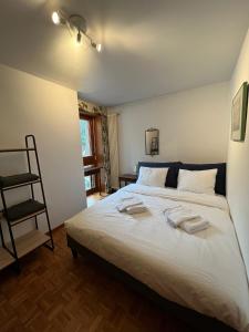 - une chambre avec un lit et 2 serviettes dans l'établissement Mountain View Apartment with Parking & Fast WiFi, à Crans-Montana