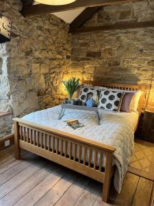 Cama en habitación con pared de piedra en Lavender Cottage en Newquay