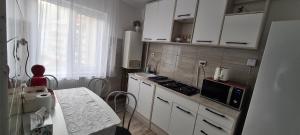a kitchen with white cabinets and a stove top oven at AKY Residence in Slănic-Moldova