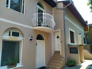 a house with a balcony and a door at Apartments Pia in Subotica