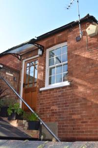 a brick house with a door and a window at Top Flat in Lincoln