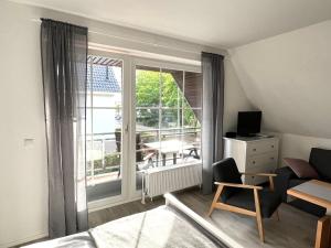 a bedroom with a large window with a view of a patio at Appartementhaus Müller in Niendorf