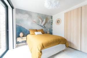 - une chambre avec un lit orné d'une peinture murale dans l'établissement Le Héron Nantais, à Nantes