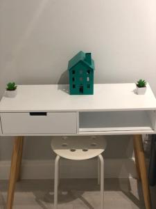 einen Schreibtisch mit einem grünen Haus darüber in der Unterkunft Cozy Flat in London! in London