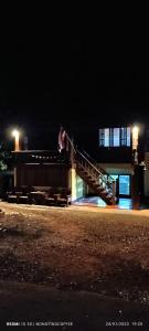 une personne assise sur un escalier dans un bâtiment la nuit dans l'établissement Chanmuang guesthouse, à Mae Hong Son