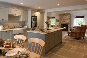 cocina con mesa, sillas y chimenea en Coach House, en Perth