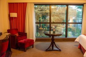 ein Hotelzimmer mit einem Tisch und einem Fenster in der Unterkunft Hotel Casino Acaray in Ciudad del Este