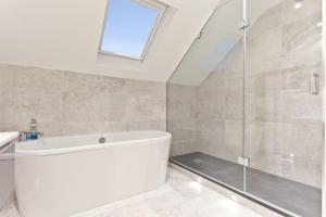 a bathroom with a white tub and a shower at Forge Bridge Cottage Coniston in Coniston +7 photos