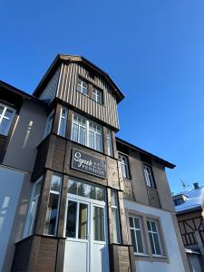 a building with a sign in front of it at SYNEK Pension in Špindlerův Mlýn