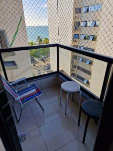 a balcony with two chairs and a table at Apt - Orla de Maceio in Maceió