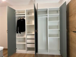 um closet com portas e prateleiras brancas em FeWo Immenstadt Apartment em Immenstadt im Allgäu